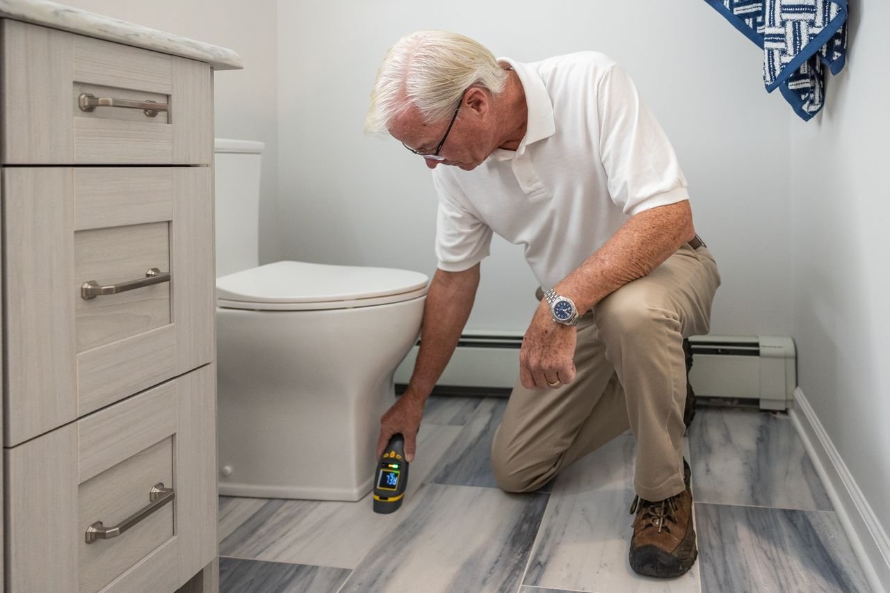 Plumber using a moisture detection device to trace a hidden leak